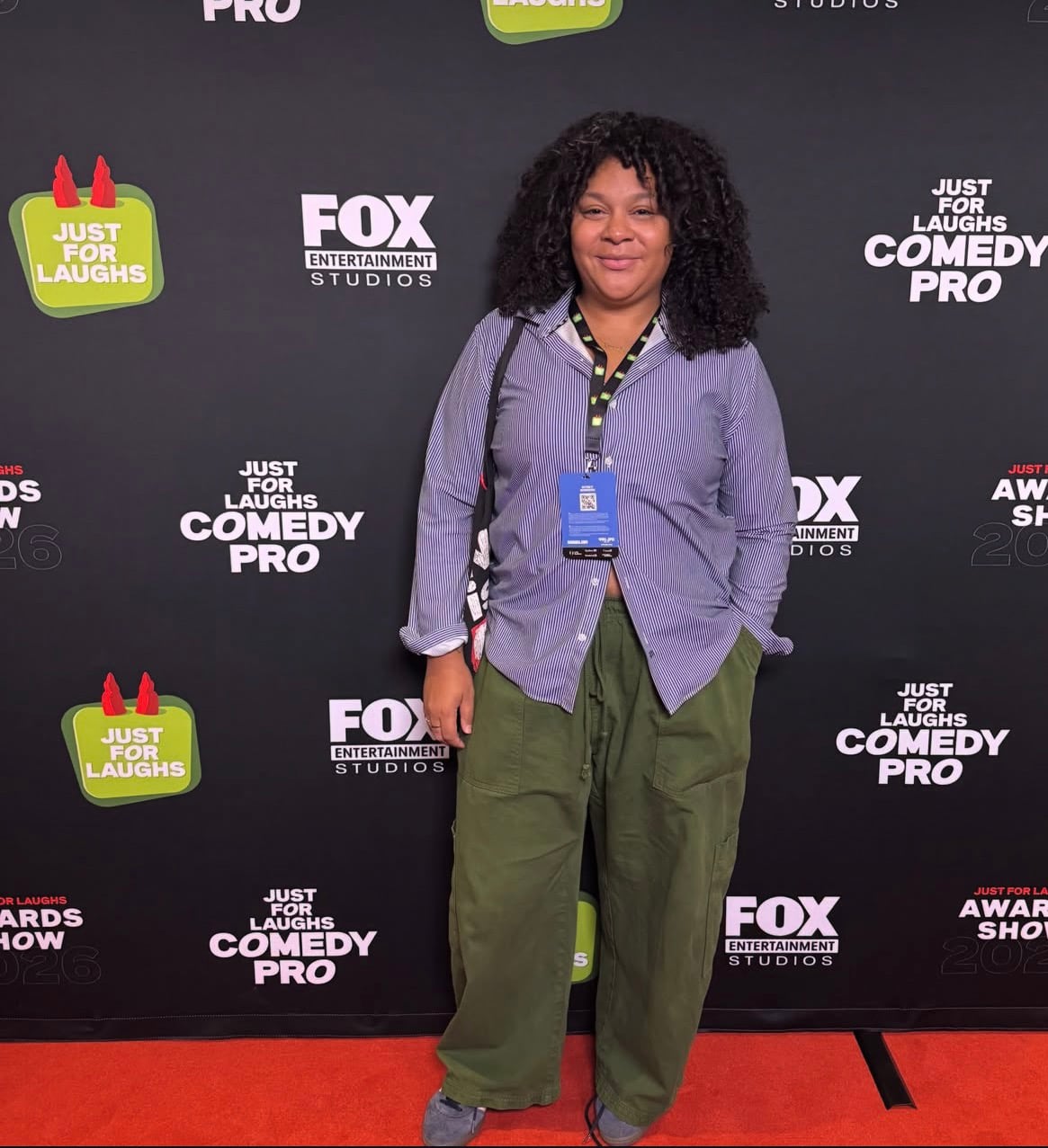 Carolina Montesquieu posa frente a un fondo de Just for Laughs ComedyPRO con logotipos del festival.
