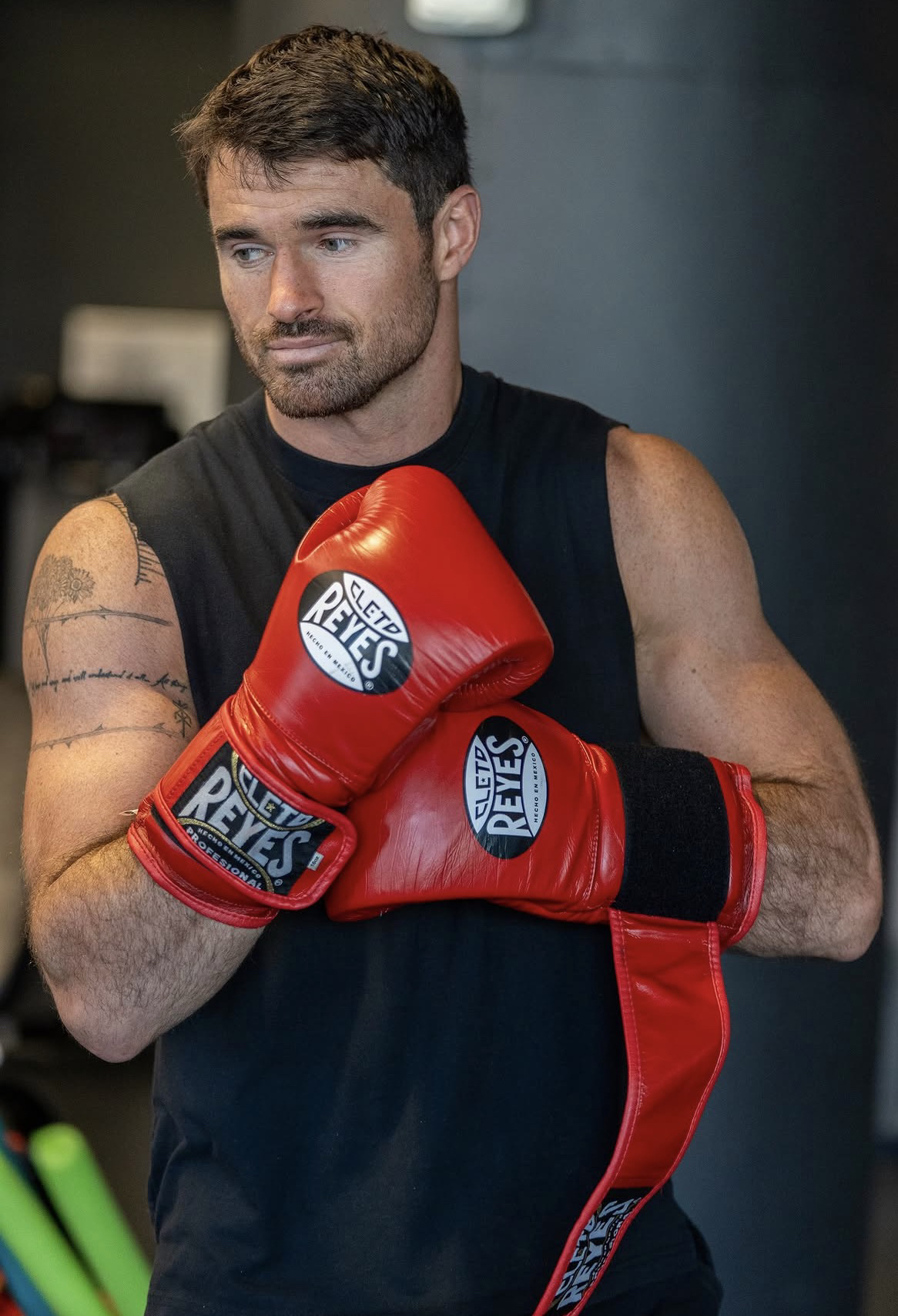 Barrett Hanlon con guantes de boxeo rojos cruzados frente al pecho