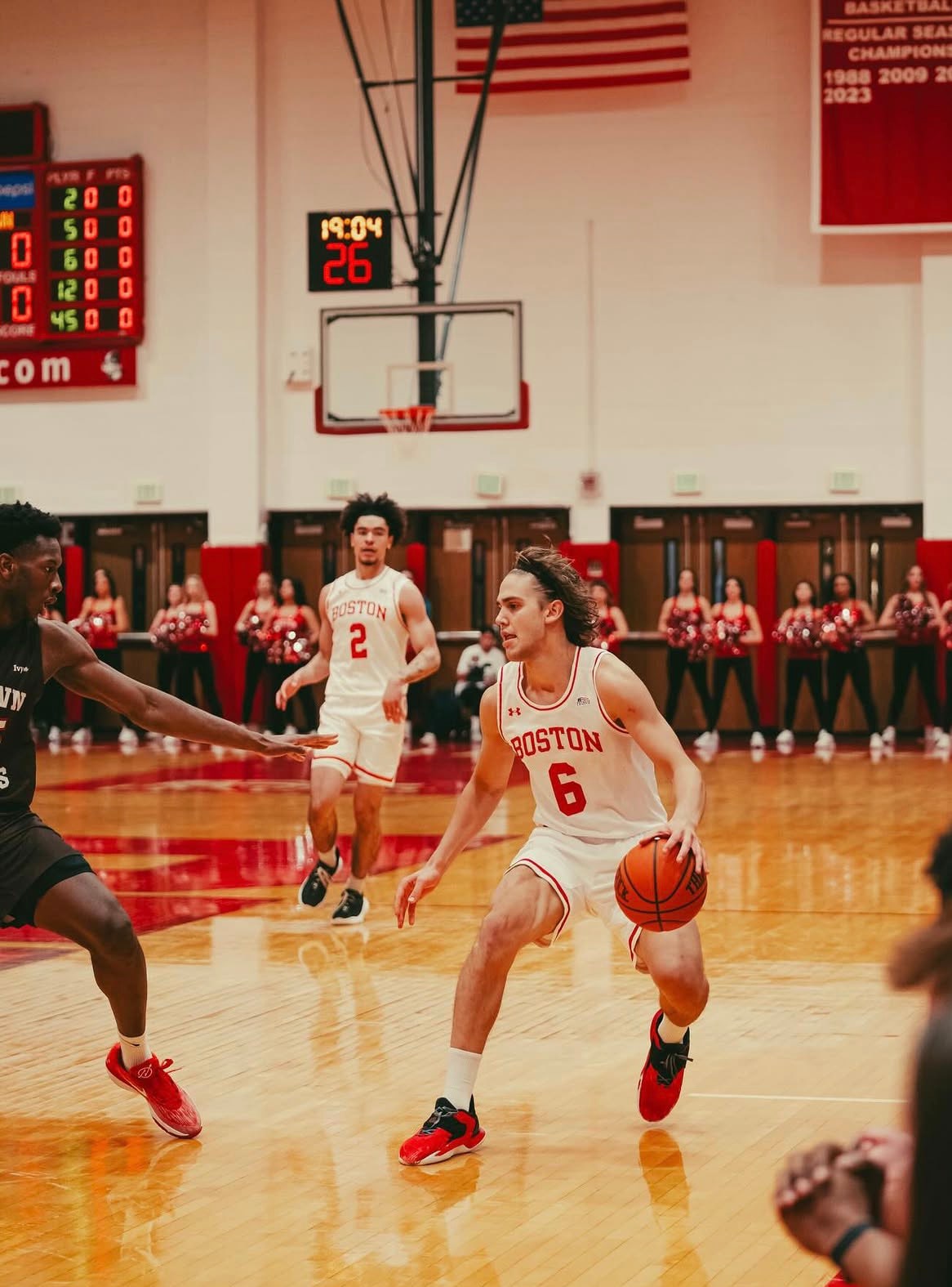 Sam Hughes penetrando ante un defensor con el uniforme de Boston University