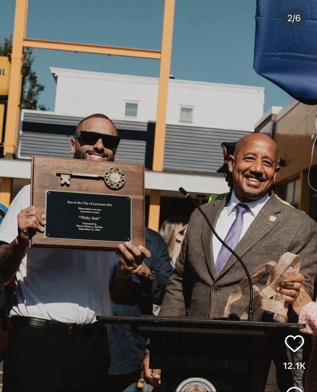 Nicky Jam sostiene la placa de la Llave de la Ciudad de Lawrence, junto al alcalde Brian A. DePeña