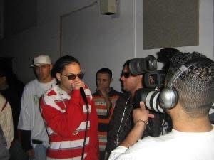 Noche De Humo 2, George Hernandez Cultural Center, South End, Boston. Un momento de prensa/entrevista — un camarógrafo filmando a un artista con un micrófono de mano.