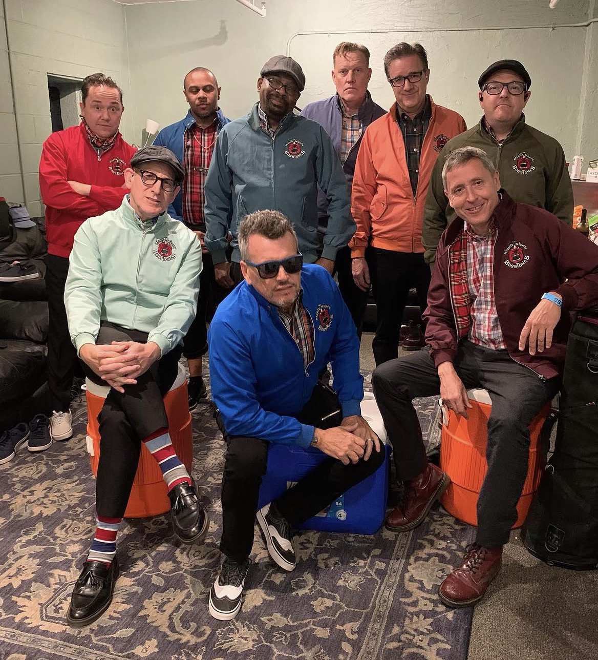 Los nueve integrantes de la banda en su etapa final, con chaquetas con el logo oficial de The Mighty Mighty Bosstones
